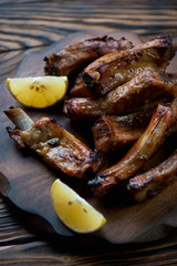 Canvas Print - Close-up of baked pork ribs with lemon, selective focus