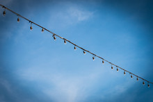 Closeup Of The Hanging Light Bulbs With Blue Sky 2