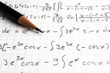 Maths concept - pencil over a sheet of paper with maths-formulas
