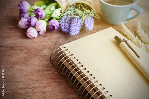 Fotografie, Tablou Cup of coffee with flower and blank notebook on wooden table