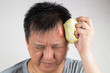 © ThamKC - Man treating his injured painful swollen forehead bump with icepack