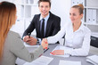 © rogerphoto - Business people shaking hands, finishing up a meeting