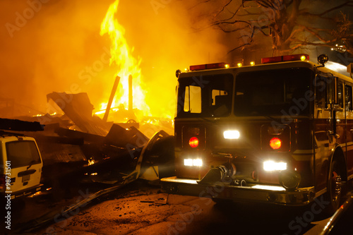 Fotografie, Obraz Major building fire with fire engine, smoke and heavy flame.