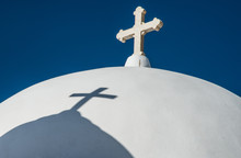 A Cross And A Shadow Of Another Cross Atop A Greek Orthodox Church Near Fira Town On The Island Of Santorini