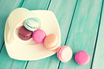 Wall Mural - Colorful macaroons in a plate over turquoise wood