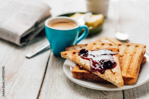 человек завтракает за столом с тостами и кофе
