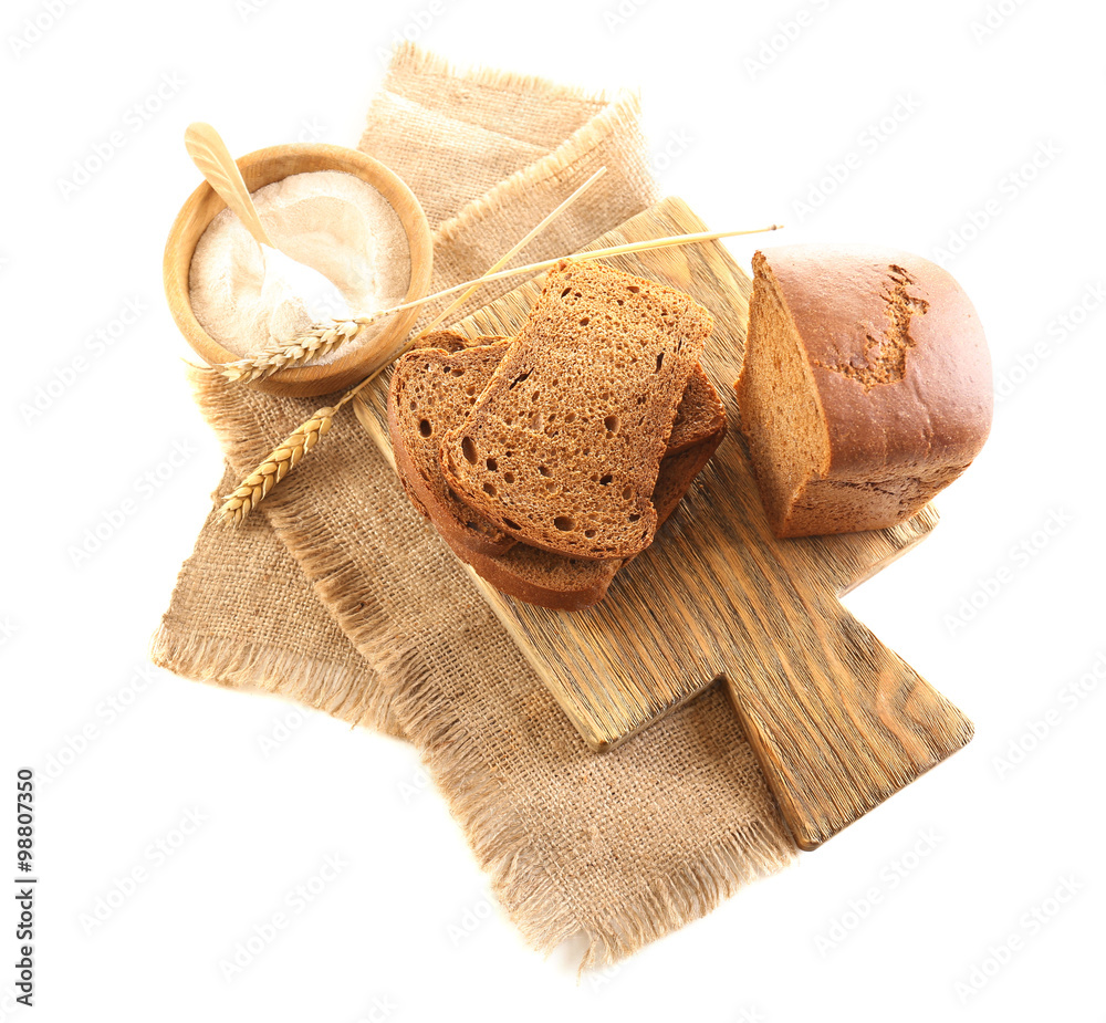 Sliced bread with ears and flour on napkin isolated on white