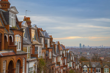 Wall Mural - Traditional British brick houses on a cloudy morning with east London at background. Panoramic shot from Muswell Hill, London, UK