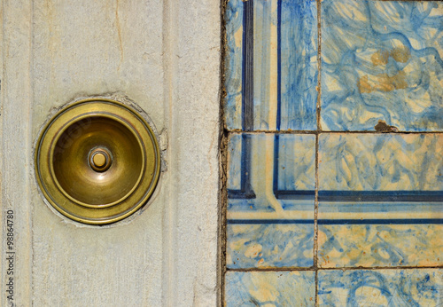 Photographie Antique brass doorbell on a building facade with ancient tiles