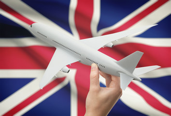 Wall Mural - Airplane in hand with flag on background - United Kingdom