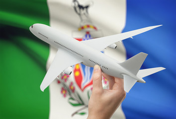 Wall Mural - Airplane in hand with Canadian province flag on background - Yukon