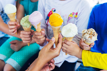 6 corns of colorful ice cream holding by kids