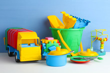 Collection Of Bright Toys On Wooden Table On Blue Background