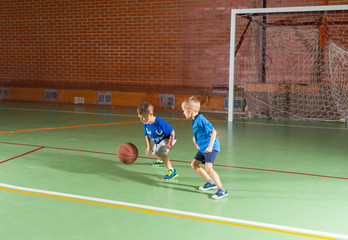 Two young boys playing a game of basketball