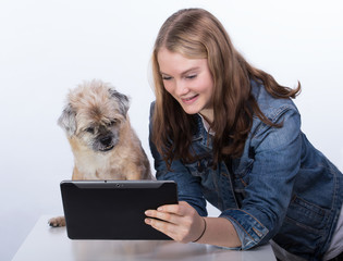 Junges Mädchen  erklärt einem kleinen Hund das Tablet