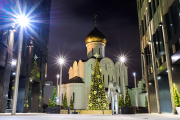 Wall Mural - New Year tree and holiday Christmas decorations in the street near metro subway station Belorusskaya at night in Russia, Moscow business center