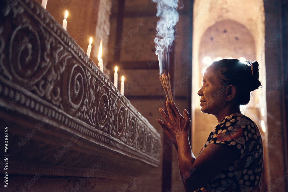 Burmese woman praying in temple - obrazy, fototapety, plakaty 