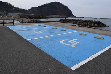 障害者用駐車場／山形県庄内地方で、車椅子マークがペイントされた障害者用駐車場を撮影した写真です。