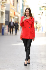 Poster - Fashion woman texting a smart phone in winter