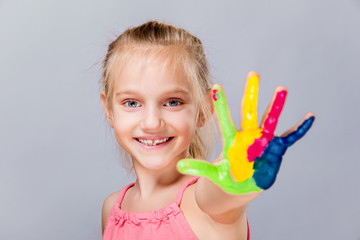 Colorful painted hands in a beautiful young girl.