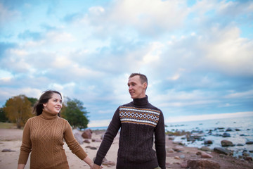 Wall Mural - young couple walking on the rocky beach