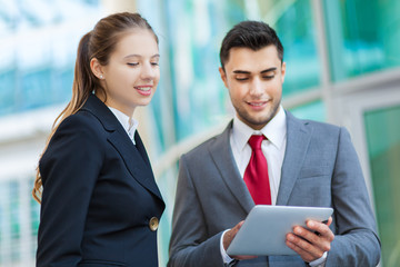 Wall Mural - Couple of business people using a tablet outdoor