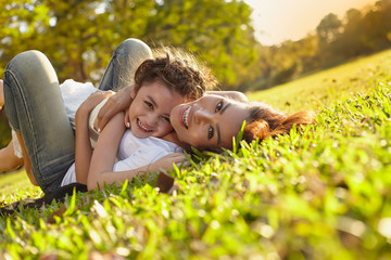 Lifestyle portrait mom and daughter in happines at the outside in the meadow