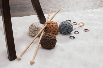 button and woolen yarn ball on carpet