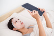 © leungchopan - Woman using facial mask and tablet pc