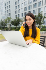 Poster - Woman make a call by cellphone and use of the notebook computer