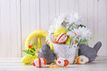 Colorful easter eggs and decorative birds on white  wooden backg