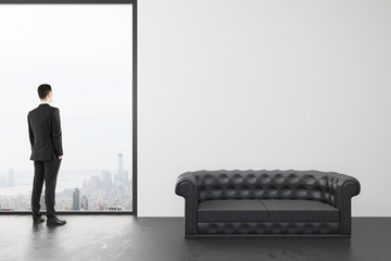 Poster - Businessman in loft room with black leather sofa and window in f