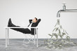 Businessman resting on a chair and faucet from which the money f