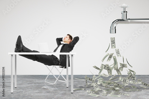 Fotografía Businessman resting on a chair and faucet from which the money f