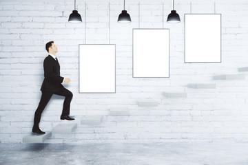 Poster - Businessman climbs up the stairs at white brick wall with blank