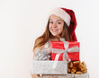 © Nastassia Yakushevic - happy smiling young girl in Santa hat with gifts for Christmas