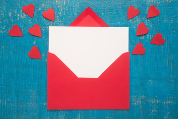 Wall Mural - Red envelope with hearts on  wooden background 