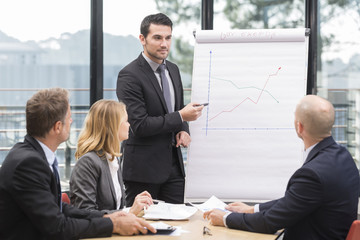 Businessmen are meeting near the flipchart