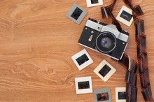 Vintage Camera, Slides And Negatives On Wooden Background
