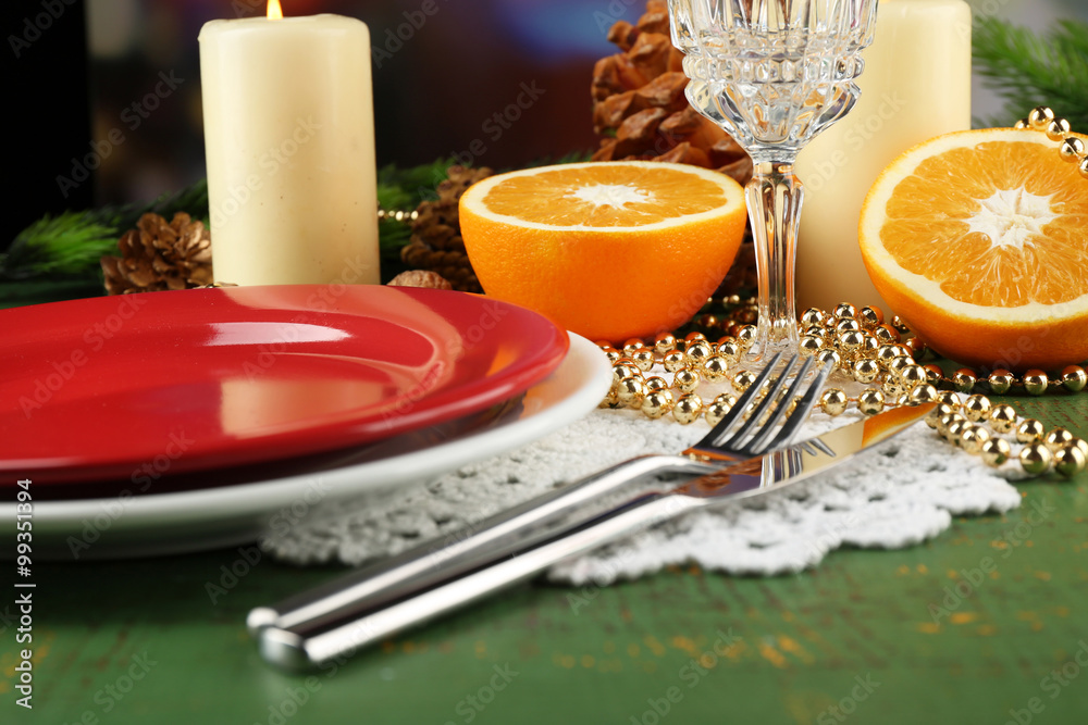 Table appointments with pieces of orange and Christmas decoration background