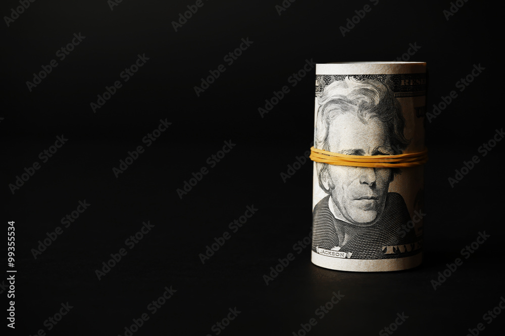 Dollars roll on black background