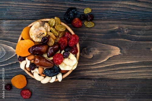 Cuadros en Lienzo Mix of dried fruits and nuts on a dark wood background with copy space