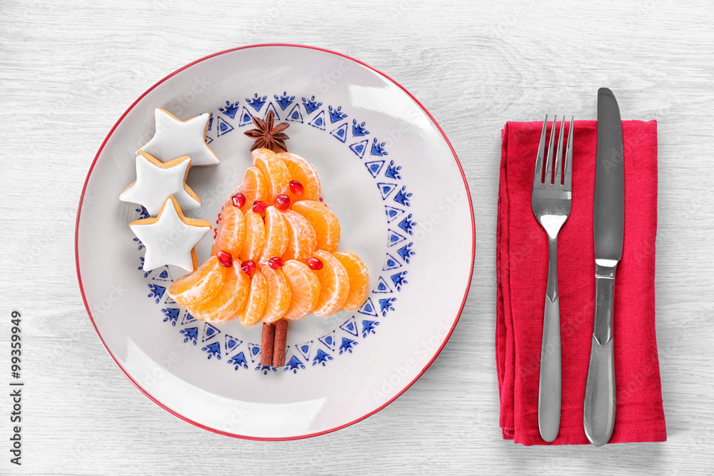 Christmas fir tree made from tangerines, on plate, close up