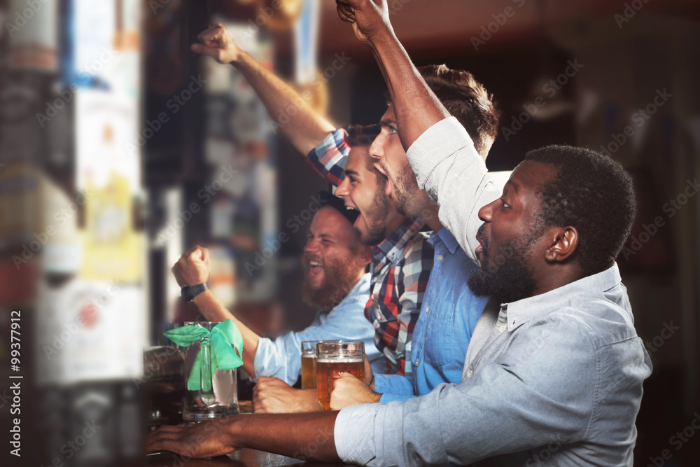 Young men drinking beer in pub