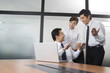 © Blue Jean Images - Young businessmen and businesswoman chatting in office
