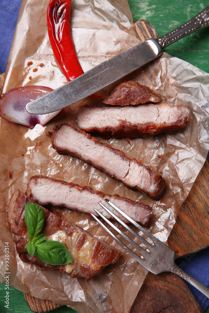 Roasted beef fillet and vegetables on cutting board, on wooden background