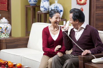 Wall Mural - Excited senior couple on the phone during Chinese New Year