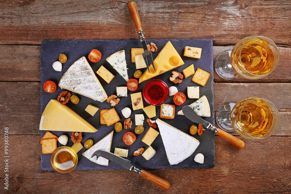 Cheese for tasting on wooden background, top view
