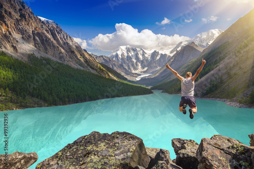 Fotomural Beautiful mountain landscape with lake and jumping man
