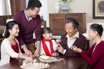 Wall Mural - Happy family making Chinese dumplings during Chinese New Year